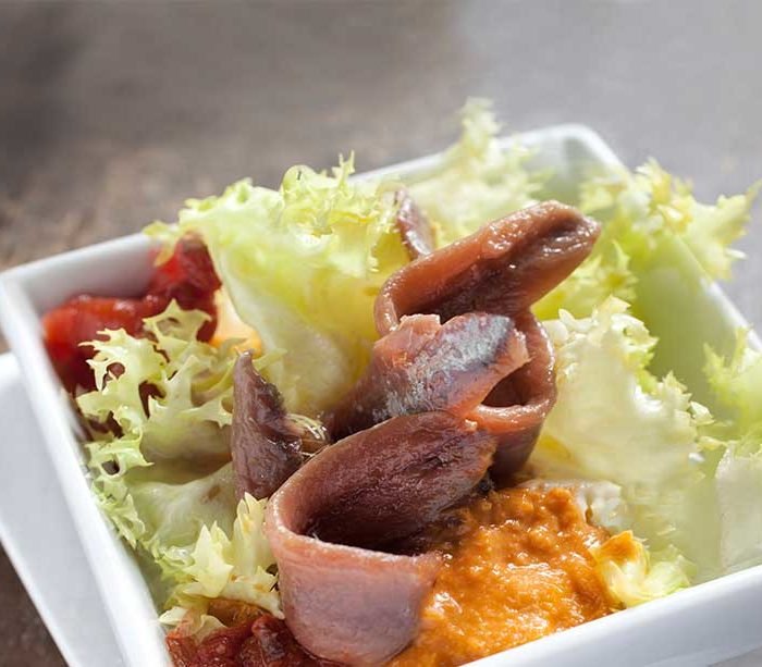 Escarole salad with a light romesco sauce and anchovies