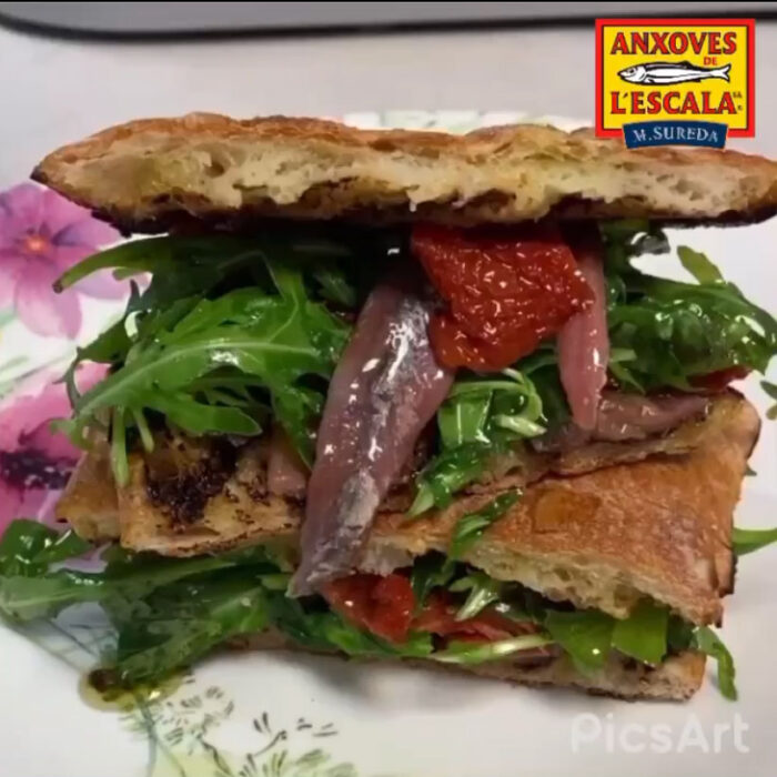 Planchadito de tomate confitado, rúcula y anchoas